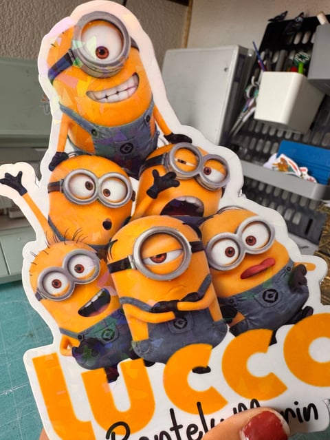 A die-cut cardboard standup of five yellow Minions characters stacked together with playful expressions in an office setting.